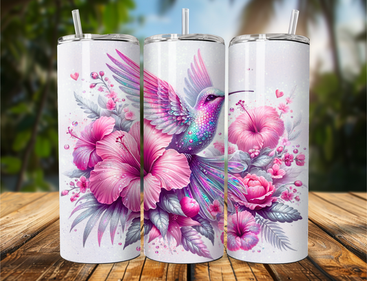 "Tumbler featuring a pink, teal, and white hummingbird perched on coordinating flowers with a clean white background. Available in 20oz or 30oz sizes."