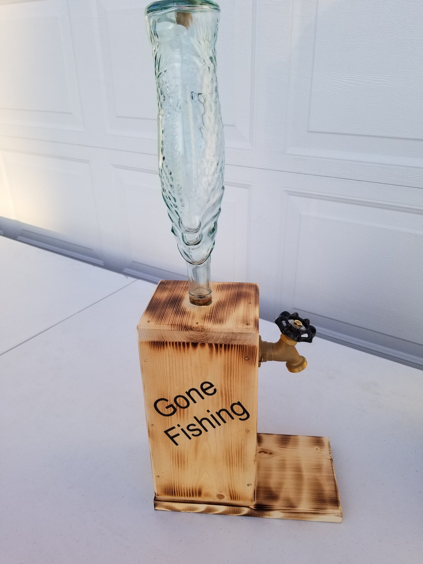 Liquor dispenser with fish-shaped bottle and ‘Gone Fishing’ burned into the sides.