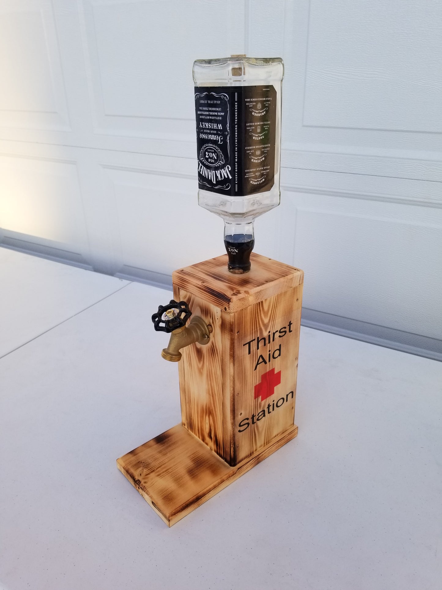 Rustic Jack Daniel’s liquor dispenser with permanent bottle, spigot, and refill funnel.