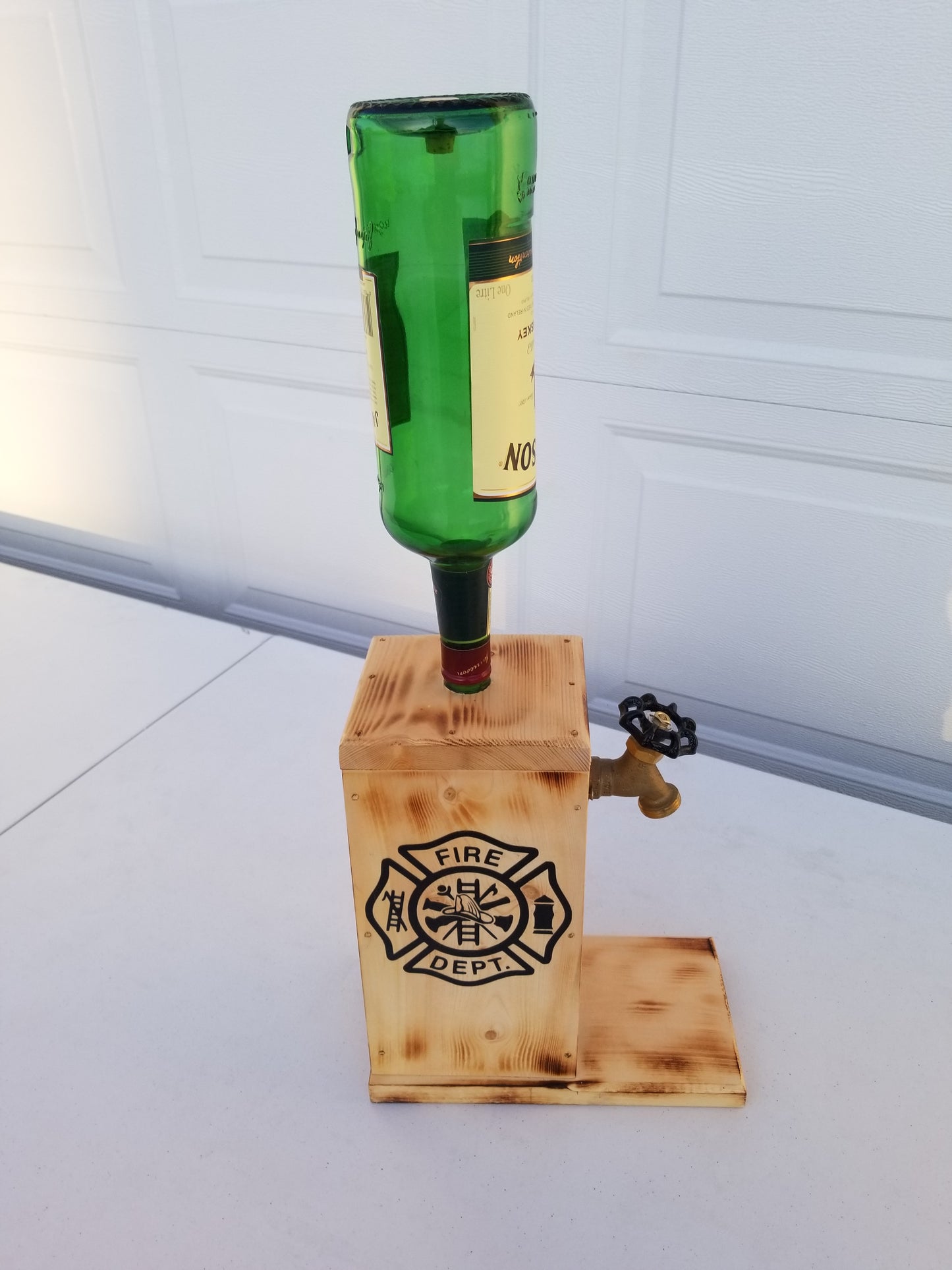 Jameson liquor dispenser with permanent bottle, spigot, and refill funnel.