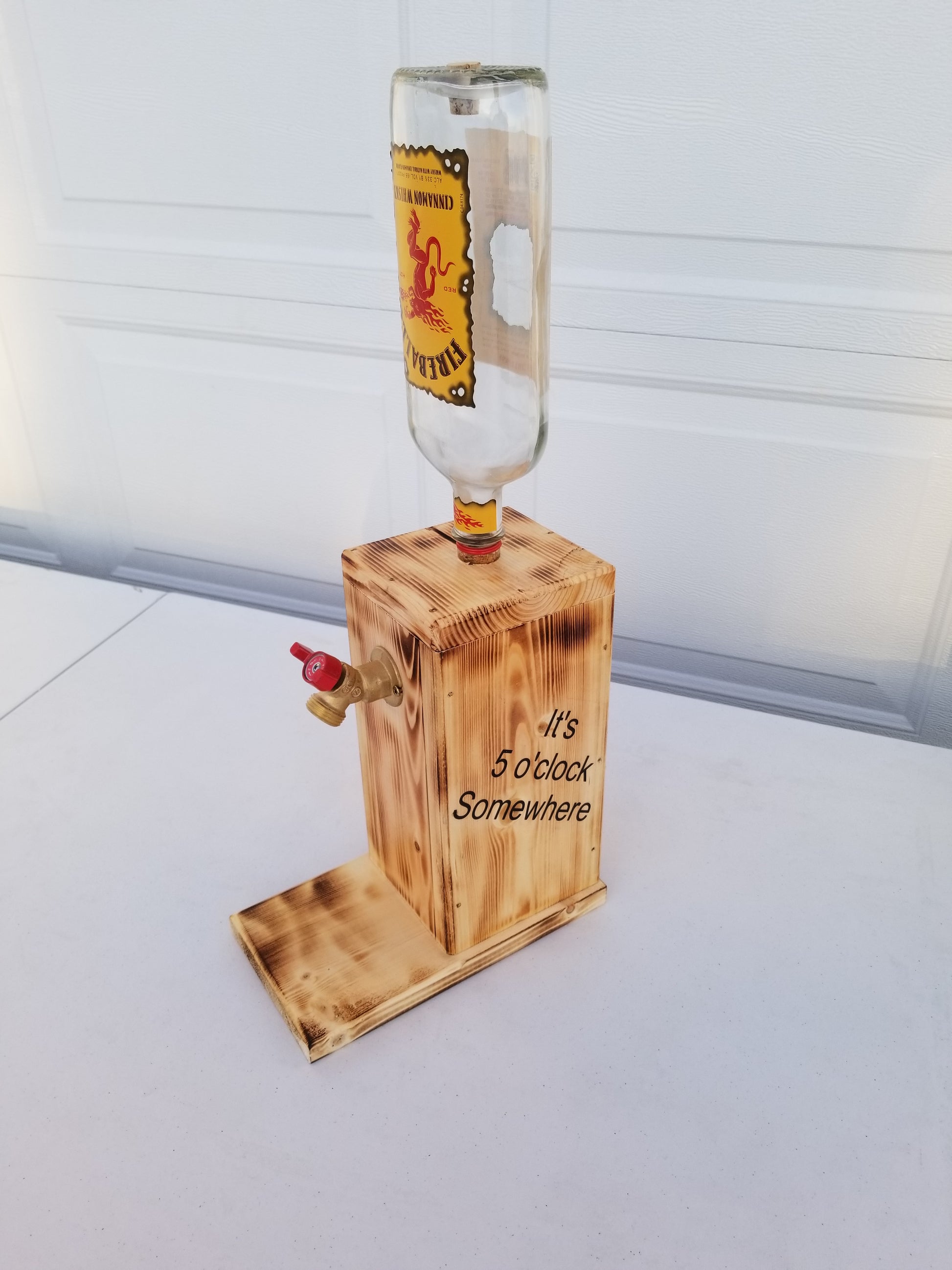 Fireball liquor dispenser with ‘It’s 5 o’clock Somewhere’ burned on both sides.