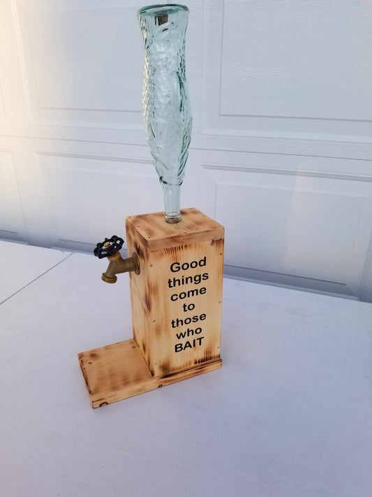 Liquor dispenser with fish-shaped bottle and ‘Good Things Come to Those Who Bait’ burned into the sides.