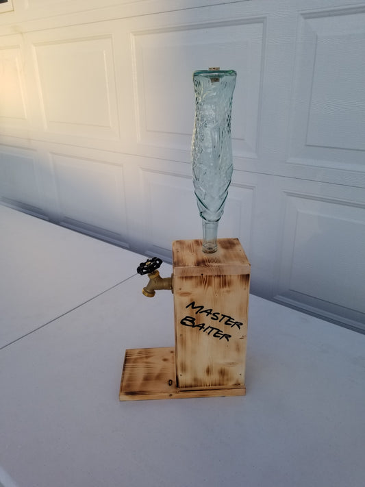 Liquor dispenser with fish-shaped bottle and ‘Master Baiter’ burned on both sides.