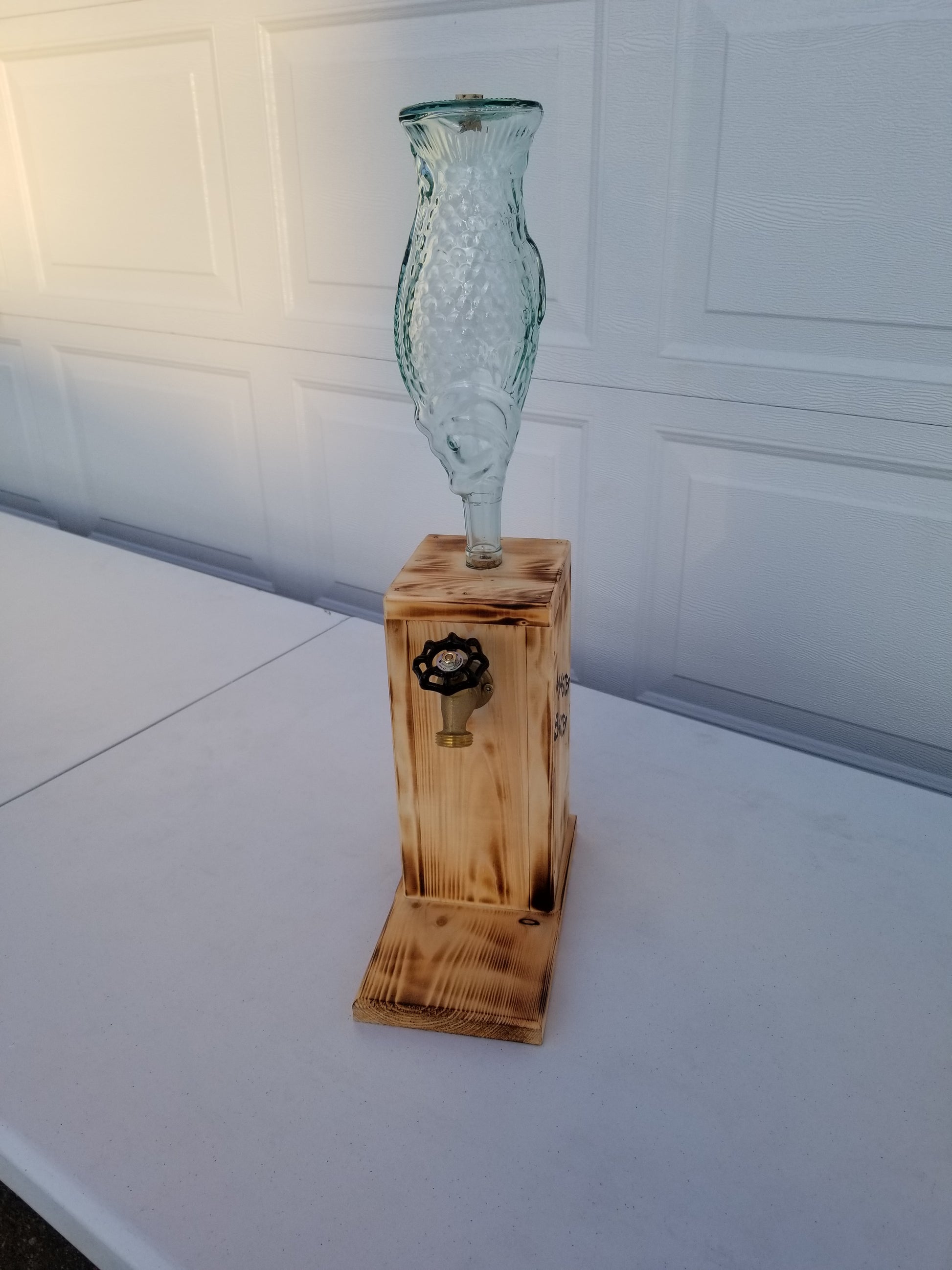 fish bottle liquor dispenser with humorous fishing saying.