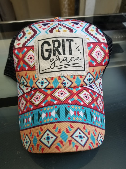 A colorful Aztec patterned hat with 'GRIT AND GRACE' text on the front.
