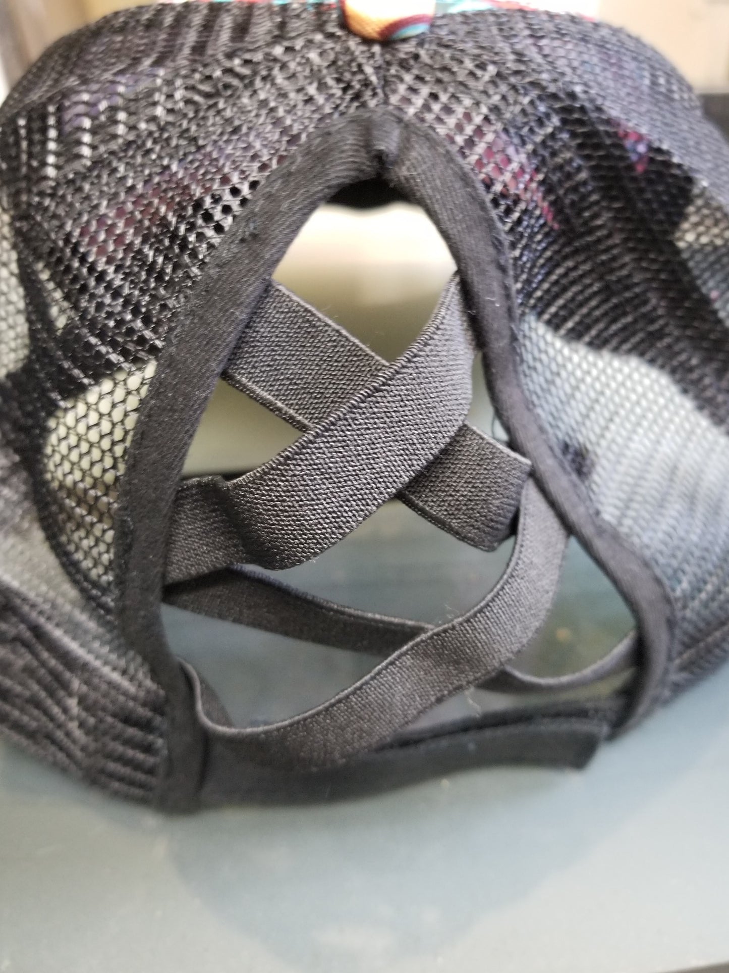 Back view of crisscross ponytail hat with black mesh and adjustable strap