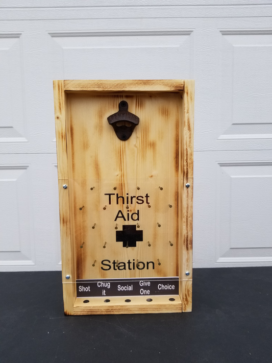 A wooden drinking game board with a bottle opener at the top. The board is labeled 'Thirst Aid Station' and has various sections for different tasks such as 'Shot', 'Chug', 'Social', 'Give', and 'Choice'.