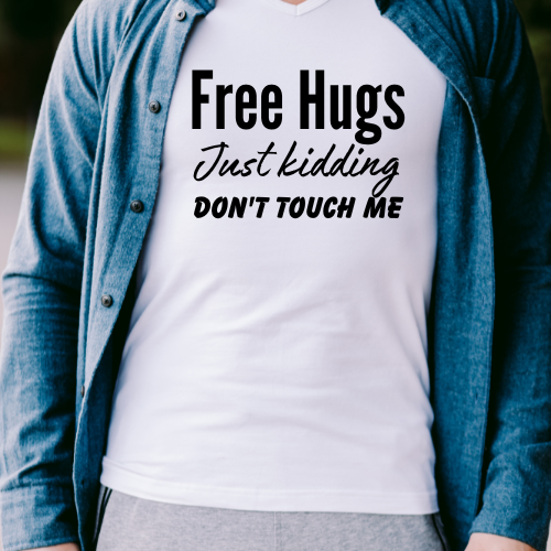 A person wearing a white t-shirt with the text 'Free Hugs Just kidding DON'T TOUCH ME' printed on the front.