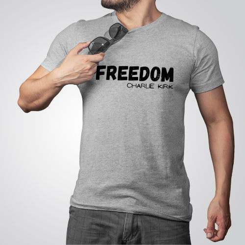 Person wearing a gray t-shirt with 'FREEDOM CHARLIE KIRK' text, holding sunglasses.