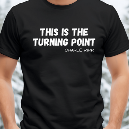 Black t-shirt with white text 'THIS IS THE TURNING POINT CHARLIE KIRK' on a blurred background
