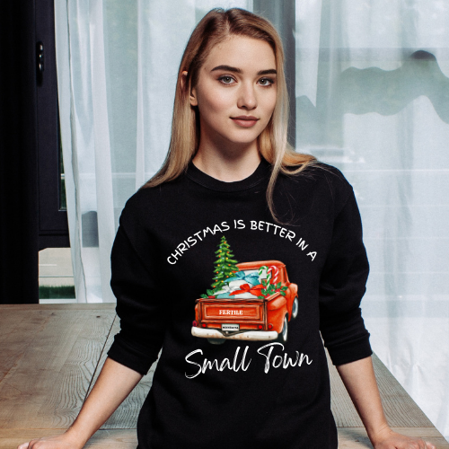 Black sweatshirt with vintage red truck and Christmas tree design reading 'Christmas Is Better in a Small Town,' featuring customizable city and state license plate.