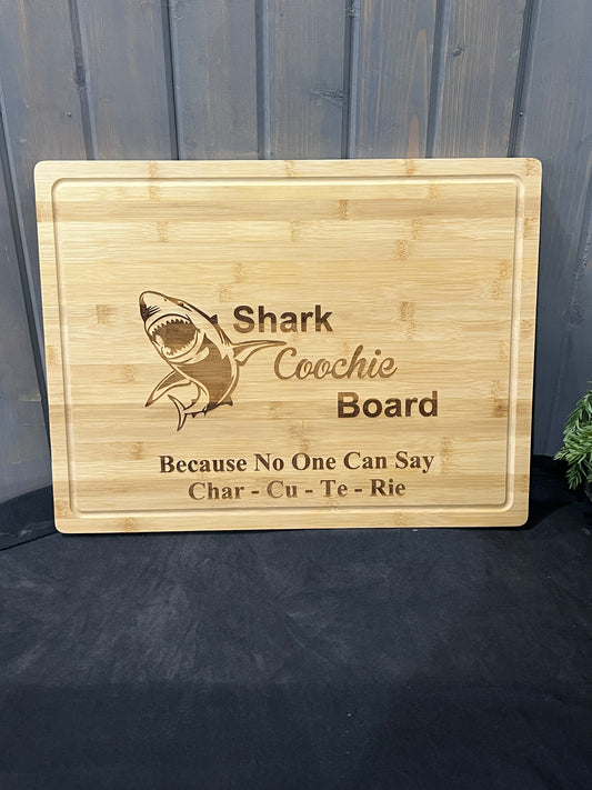 Funny bamboo cutting board engraved with shark and ‘Shark Coochie because no one can say Char-Cu-Te-Rie’ phrase, 19 ¾ x 15 x ¾ inches.