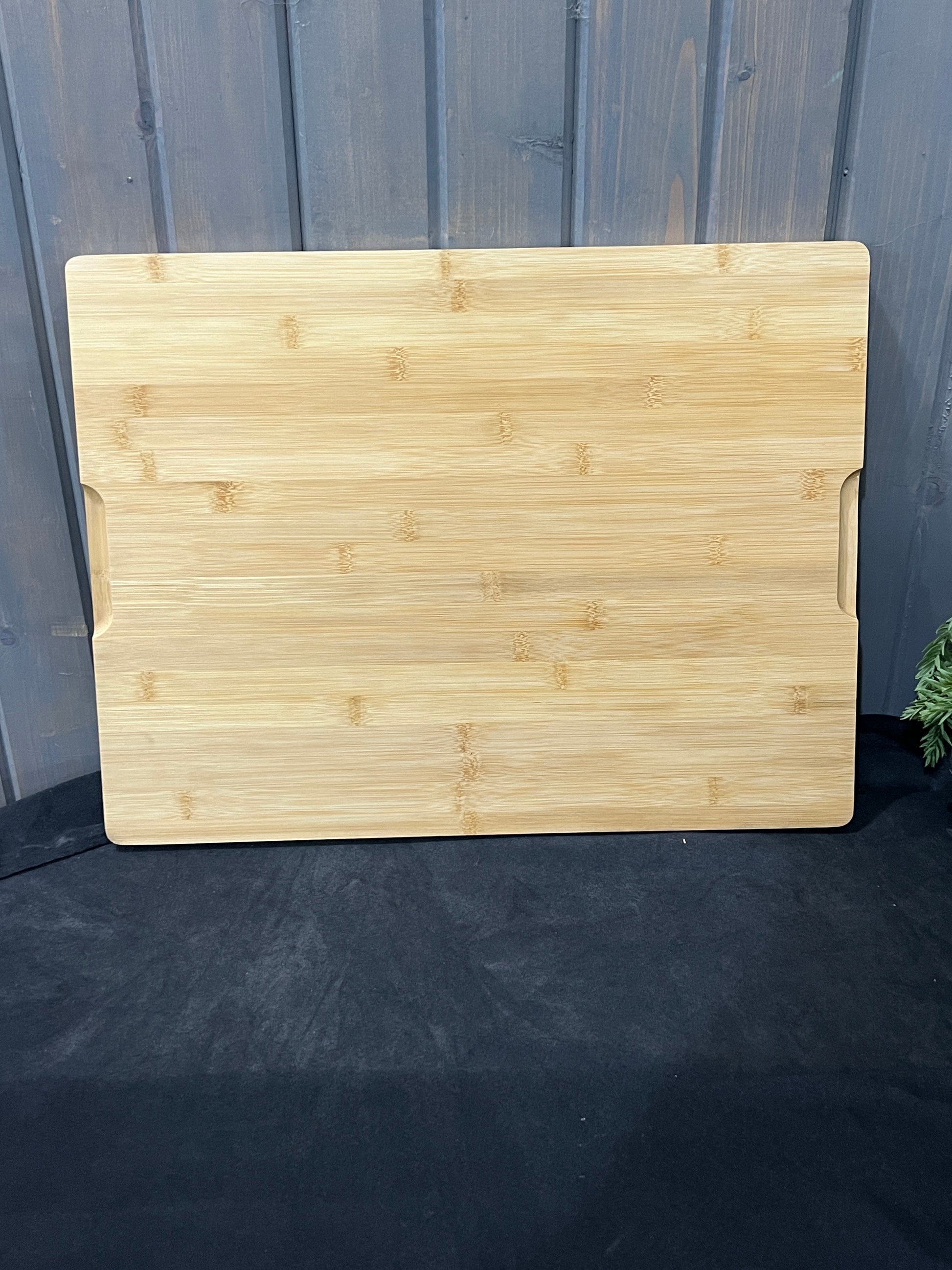 “Large engraved bamboo charcuterie board with shark design and grooved handles on back.