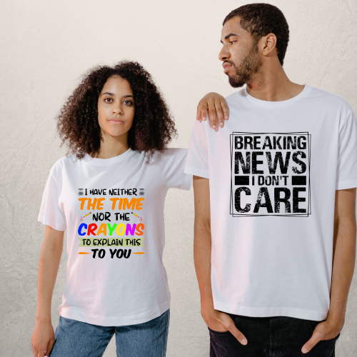 Two adults, one male and one female, wearing white t-shirts with text-based graphics. The female t-shirt has a colorful text design with the phrase 'I have neither the time nor the crayons to explain this to you', and the male t-shirt has the phrase 'BREAKING NEWS I DON'T CARE' in bold black letters.