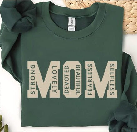 Crewneck sweatshirt featuring the word “MOM” with descriptive words like strong, lovely, and fearless designed inside the letters.