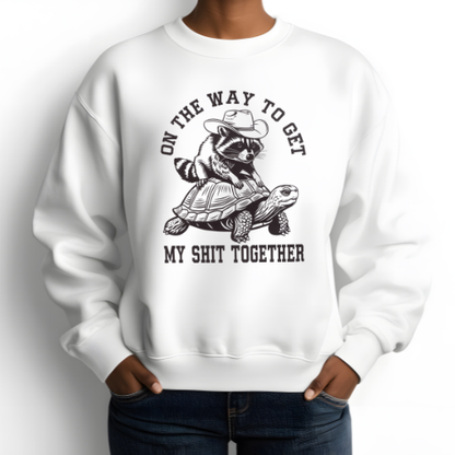 White sweatshirt with a graphic design of a raccoon and turtle, text on a white background