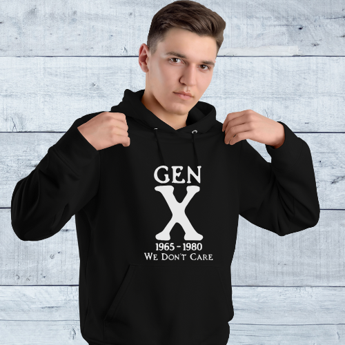 Person wearing a black hoodie with 'GEN X 1965-1980 WE DON'T CARE' text against a light wooden panel background