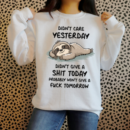 Person wearing a white sweatshirt with a sloth graphic and text on a patterned background