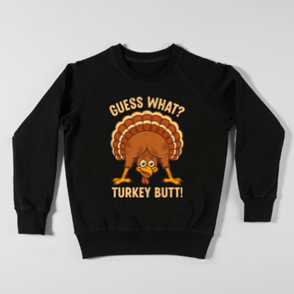 Cartoon turkey looking through his legs with the phrase “Guess What? Turkey Butt!” printed on a fall-themed shirt.