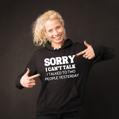 Woman wearing a black hoodie with text pointing to herself on a dark background