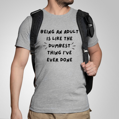 A person wearing a grey t-shirt with the text 'BEING AN ADULT IS LIKE THE DUMBEST THING I'VE EVER DONE' printed on the front.