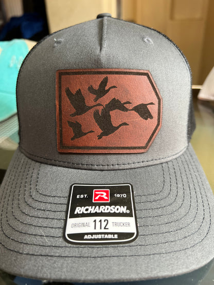 Geese flying on a leather patch hat